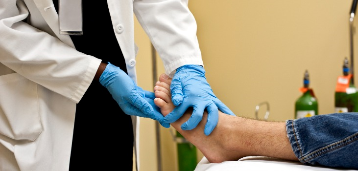 doctor examines patient's foot
